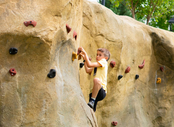 istock Caucasian boy climbing on an outdoor climbing wall 2158224151