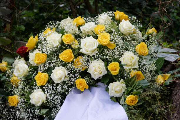 white and yellow roses decorated with gypsophila on grave