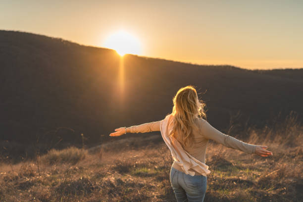 istock Woman enjoying while standing on hill at sunset 2158225133
