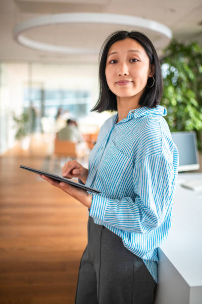 istock Asian Businesswoman with Tablet in Office Setting 2158225509