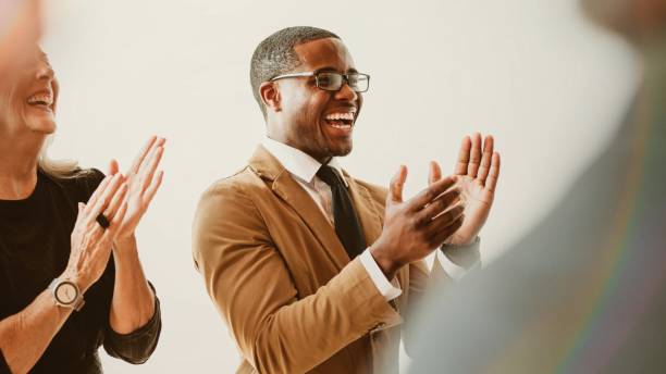 Business people clapping and applauding during a meeting, celebrating their collective success and fostering a spirit of teamwork and unity