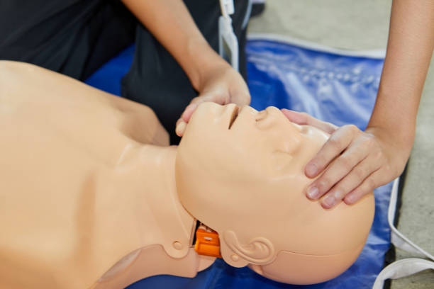 istock Cropped hands CPR First Aid training with CPR dummy in the classroom 2158226387