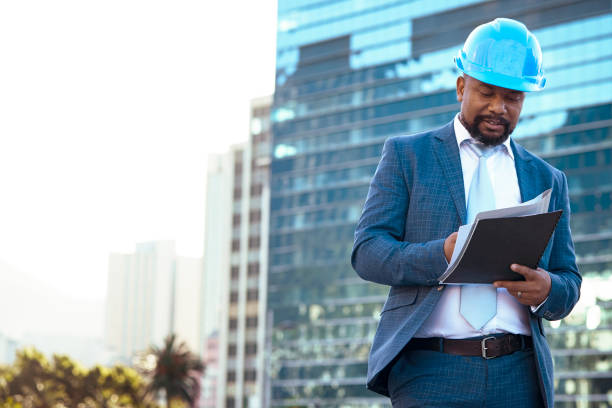 istock Businessman looking at his new building plan 2158226963