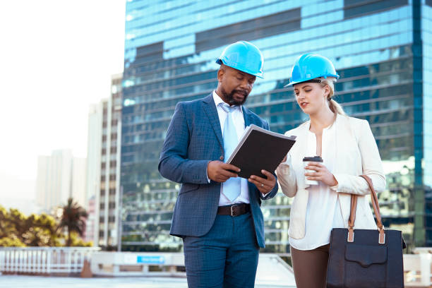 istock Colleges in hard hats discussing their new building plan 2158226964