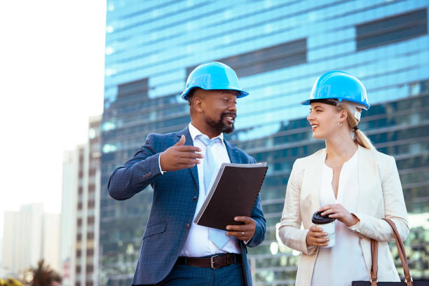 istock Colleges in hard hats discussing their new building plan 2158226966