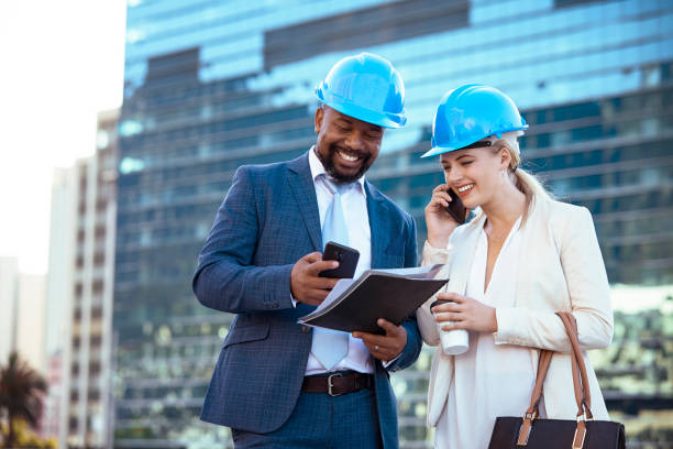 istock Colleges in hard hats discussing their new building plan 2158226969