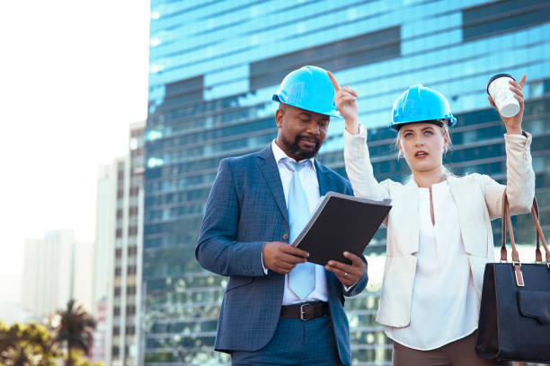 istock Colleges in hard hats discussing their new building plan 2158226987
