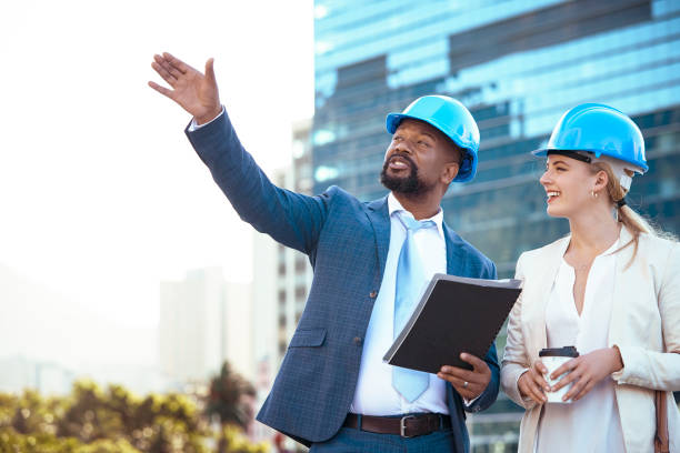istock Colleges in hard hats discussing their new building plan 2158227020
