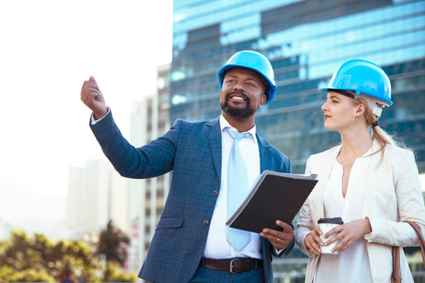 istock Colleges in hard hats discussing their new building plan 2158227066