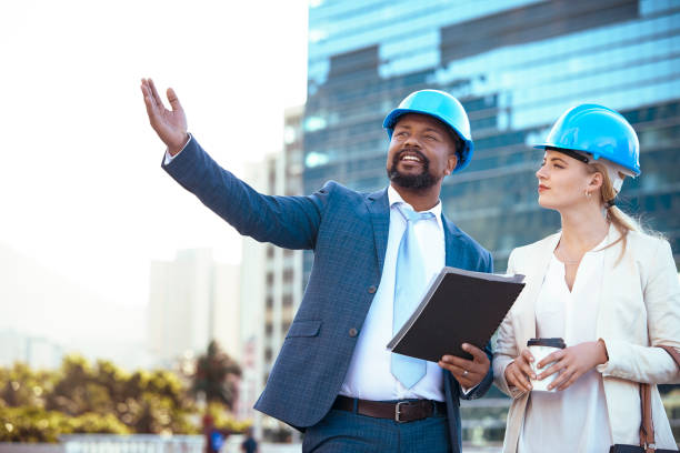 istock Colleges in hard hats discussing their new building plan 2158227073
