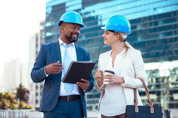 istock Colleges in hard hats discussing their new building plan 2158227076