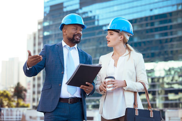 istock Colleges in hard hats discussing their new building plan 2158227081