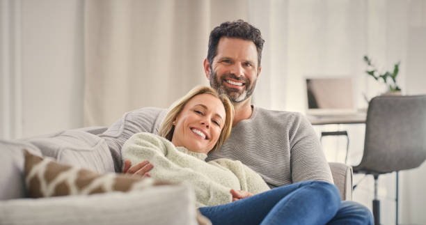 istock Hug, mature couple and happy on home sofa with smile together with commitment and care. Portrait, woman and man in love on house living room lounge couch for movie date, television bonding or romance 2158229317