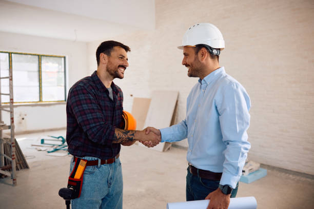 istock Happy manual worker and building contractor handshaking at construction site. 2158230602