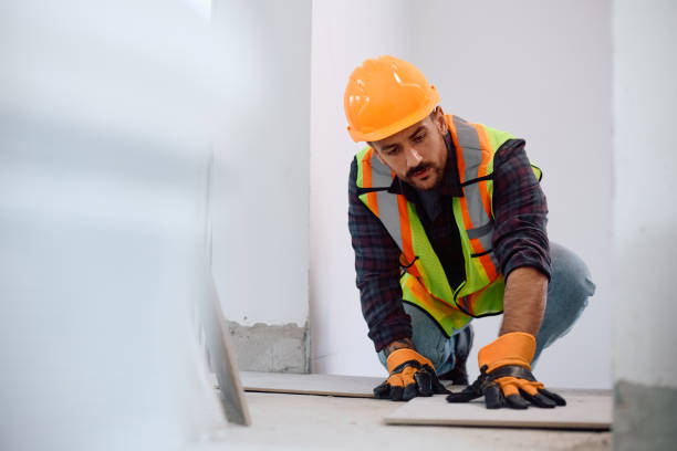 istock Construction site worker setting up floor tiles at renovating home. 2158230664