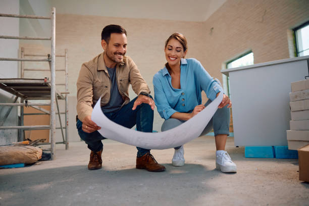 casal feliz analisando plantas durante o processo de reforma da casa. - renovação de casa - fotografias e filmes do acervo