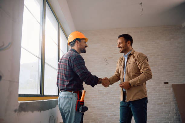 istock Happy man shaking hands with construction site worker at his renovating home. 2158230864