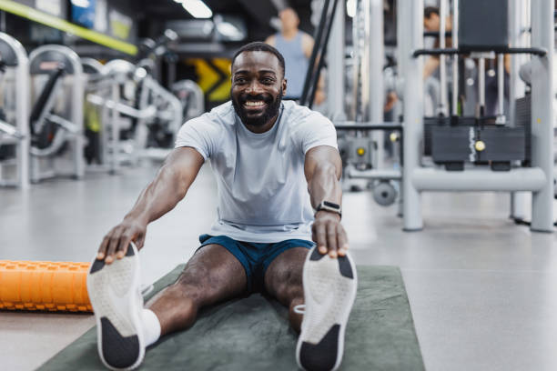 istock Man stretching in gym with foam roller 2158235904