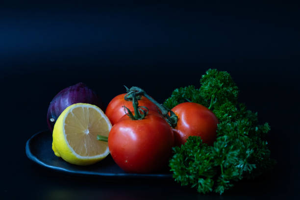 Healthy Food for modern lifestyle Fresh organics  vegetables on a black background. Tomatoes, onions, parsley.