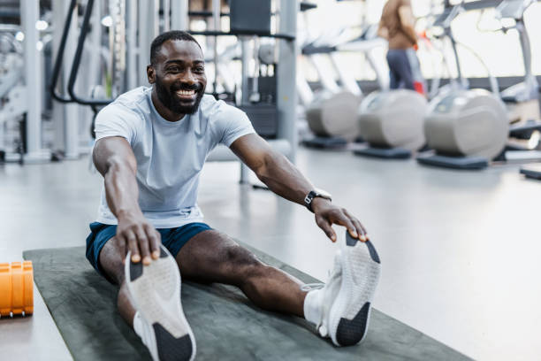 istock Man doing stretches in bright fitness center 2158236392