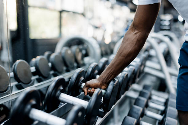istock Close-up of hand selecting weights in gym 2158236746