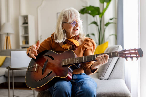 istock Charming Senior Woman Playing Acoustic Guitar 2158237846
