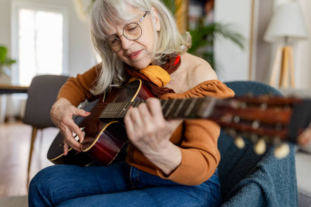 istock Charming Senior Woman Playing Acoustic Guitar 2158237913
