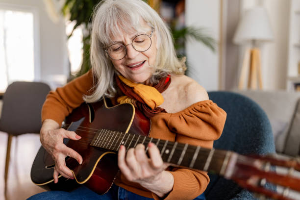 istock Charming Senior Woman Playing Acoustic Guitar 2158238113
