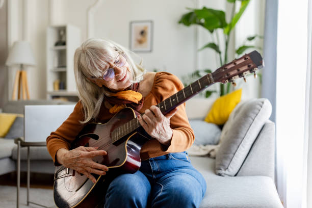 istock Charming Senior Woman Playing Acoustic Guitar 2158238325