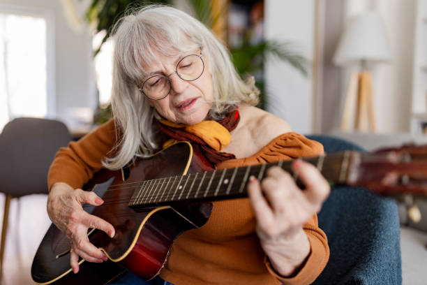 istock Charming Senior Woman Playing Acoustic Guitar 2158238428