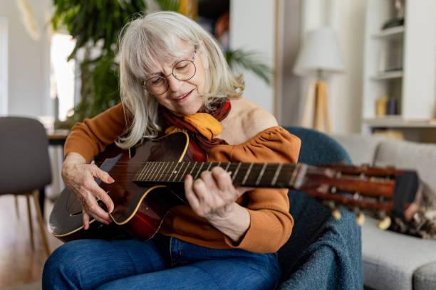 istock Charming Senior Woman Playing Acoustic Guitar 2158238444