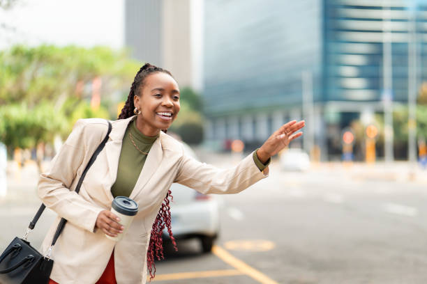 istock Confident Black Woman Entrepreneur Hailing a Cab in Urban Setting 2158238588