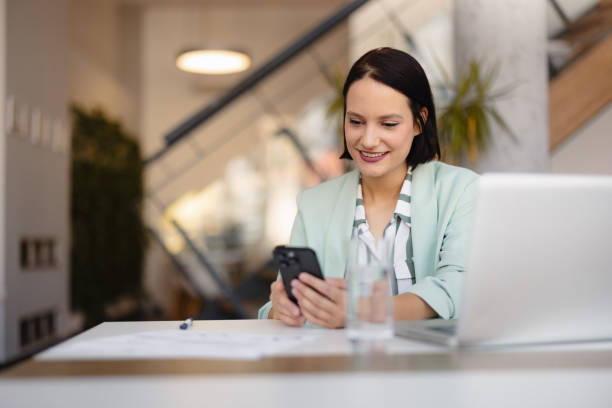 Smiling businesswoman using phone in office