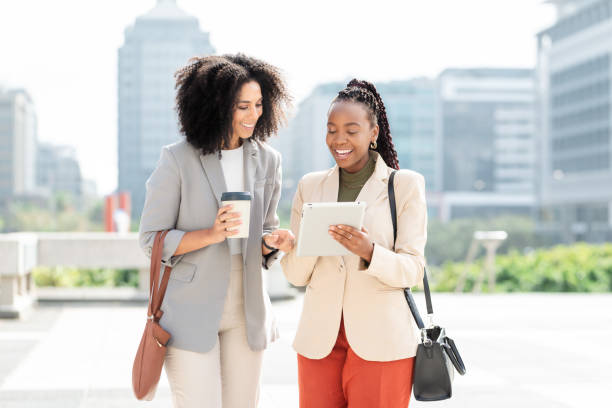 istock Two Professional Black Women Discussing Business Outside with Digital Tablet 2158239901