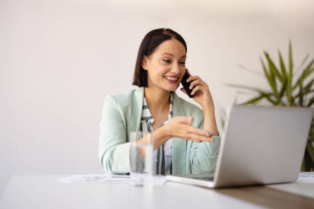 istock Smiling businesswoman using phone in office 2158240764