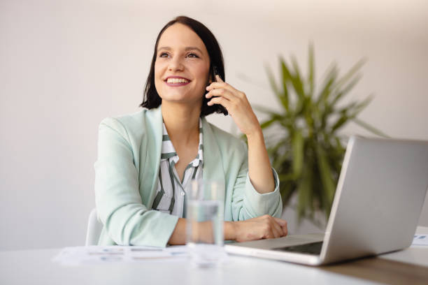 istock Smiling businesswoman using phone in office 2158240765