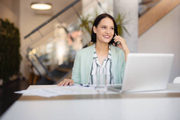 istock Smiling businesswoman using phone in office 2158240788