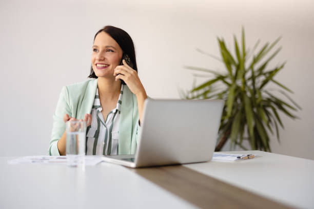istock Smiling businesswoman using phone in office 2158240797