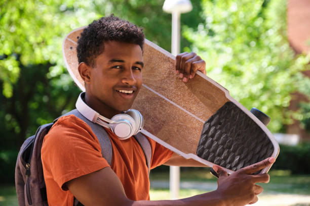 istock A young student man is holding a skateboard and smiling 2158240856