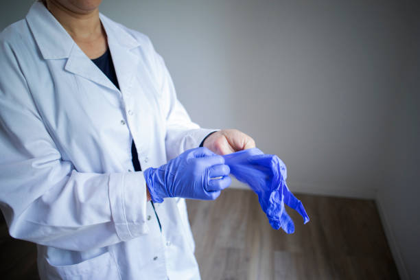 istock Female doctor putting on gloves 2158242170