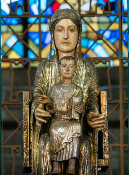 Staue of the Virgin Mary in the romanesque basilica of Orcival, Auvergne, France The Romanesque basilica towering over Orcival is one of the most impressive churches in the Auvergne. With its octagonal tower and broad stone arches, 12th-century Notre-Dame is as imposing as a castle. It was built over holy tombs laid waste by Norman invaders and today houses the 12th-century Virgin of Orcival icon, the focus of Ascension Day pilgrimages since the 6th century. Inside, take time to admire carved capitals on top of the graceful stone pillars, and the shadowy crypt. orcival stock pictures, royalty-free photos & images