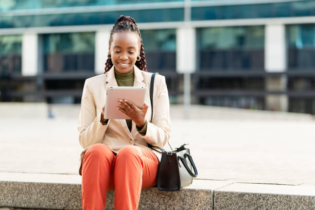 istock African American Businesswoman Using Tablet Outdoors, Smiling and Working Remotely 2158244076
