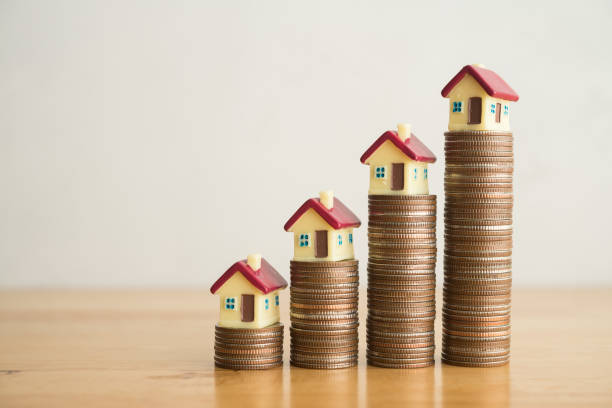 istock House on stack coin growth as chart on wooden table with white wall background. 2158245473