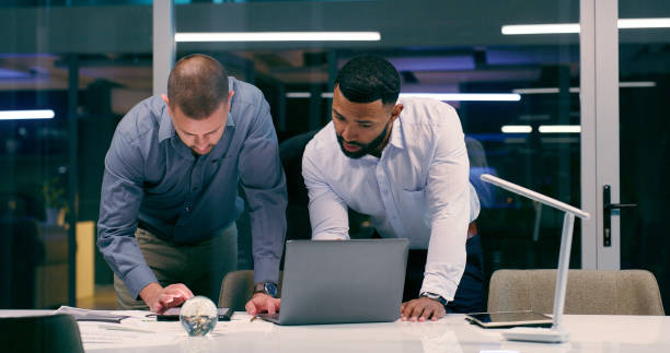 istock Men, laptop and review in workplace together for teamwork, collaboration and partnership with strategy. Detectives, technology and investigation for justice, corruption and crime with video evidence 2158245546
