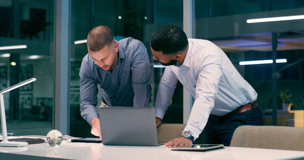 istock Man, laptop and review in workplace together for teamwork, partnership and collaboration with strategy. Detective, technology and investigation for justice, corruption and crime with video evidence 2158245547