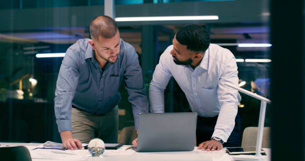 istock Men, laptop and review in workplace together for teamwork, collaboration and partnership with strategy. Detectives, technology and investigation for justice, crime and corruption with video evidence 2158245563