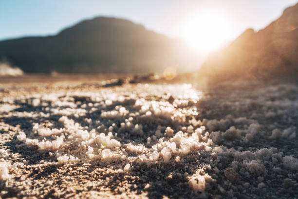 Close-up of salt formations with majestic mountains and a beautiful sunset in the Atacama Desert, Chile.