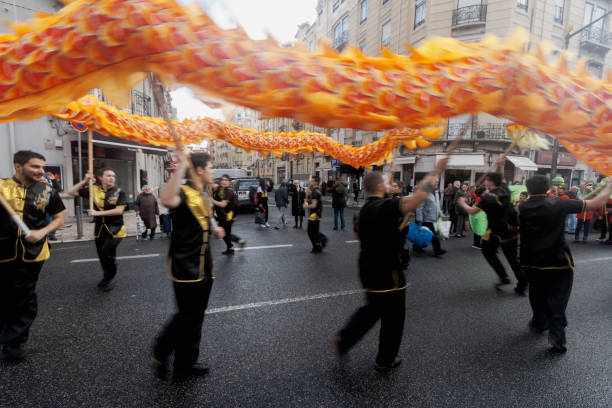 Lisbon, Portugal - January 18, 2020: Men dressed in traditional folklore costumes, wave a giant gragon during the Chinese New Year celebrations in Lisbon downtown.