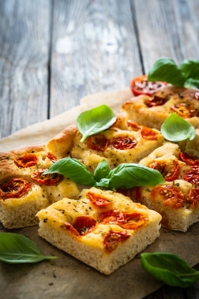 istock Focaccia - roasted mozzarella sandwiches with ham, tomatoes and arugula on black stone plate 2158254716
