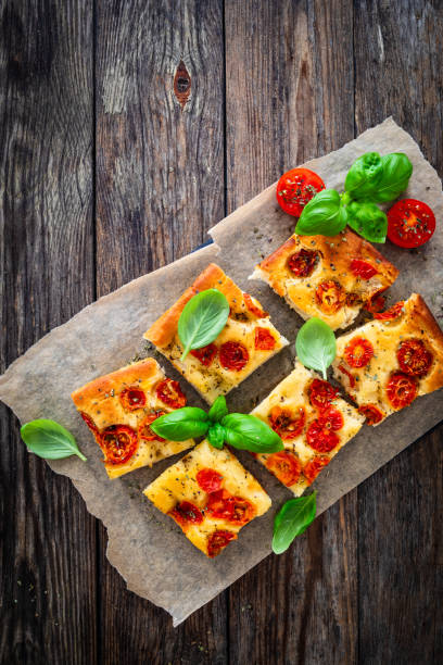 istock Focaccia - roasted mozzarella sandwiches with ham, tomatoes and arugula on black stone plate 2158254746